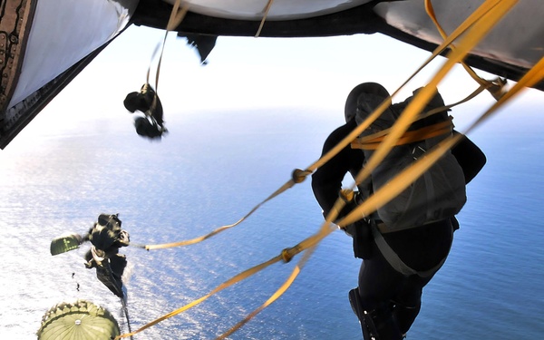 U.S. Navy Explosive Ordnance Disposal technicians perform a static line water drop.