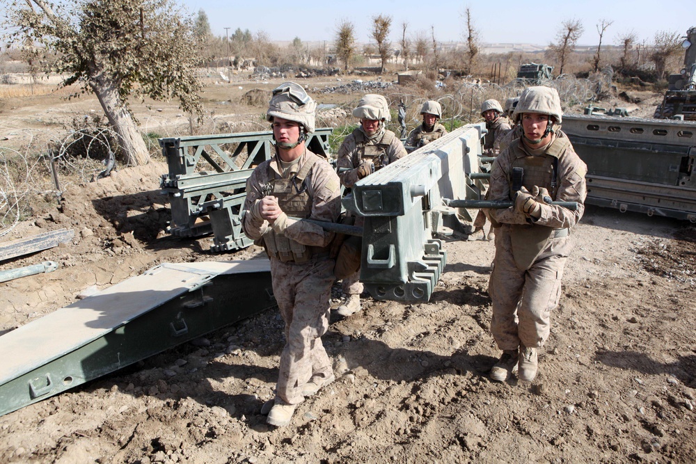 U.S. Marines carry bridge components to be assembled.