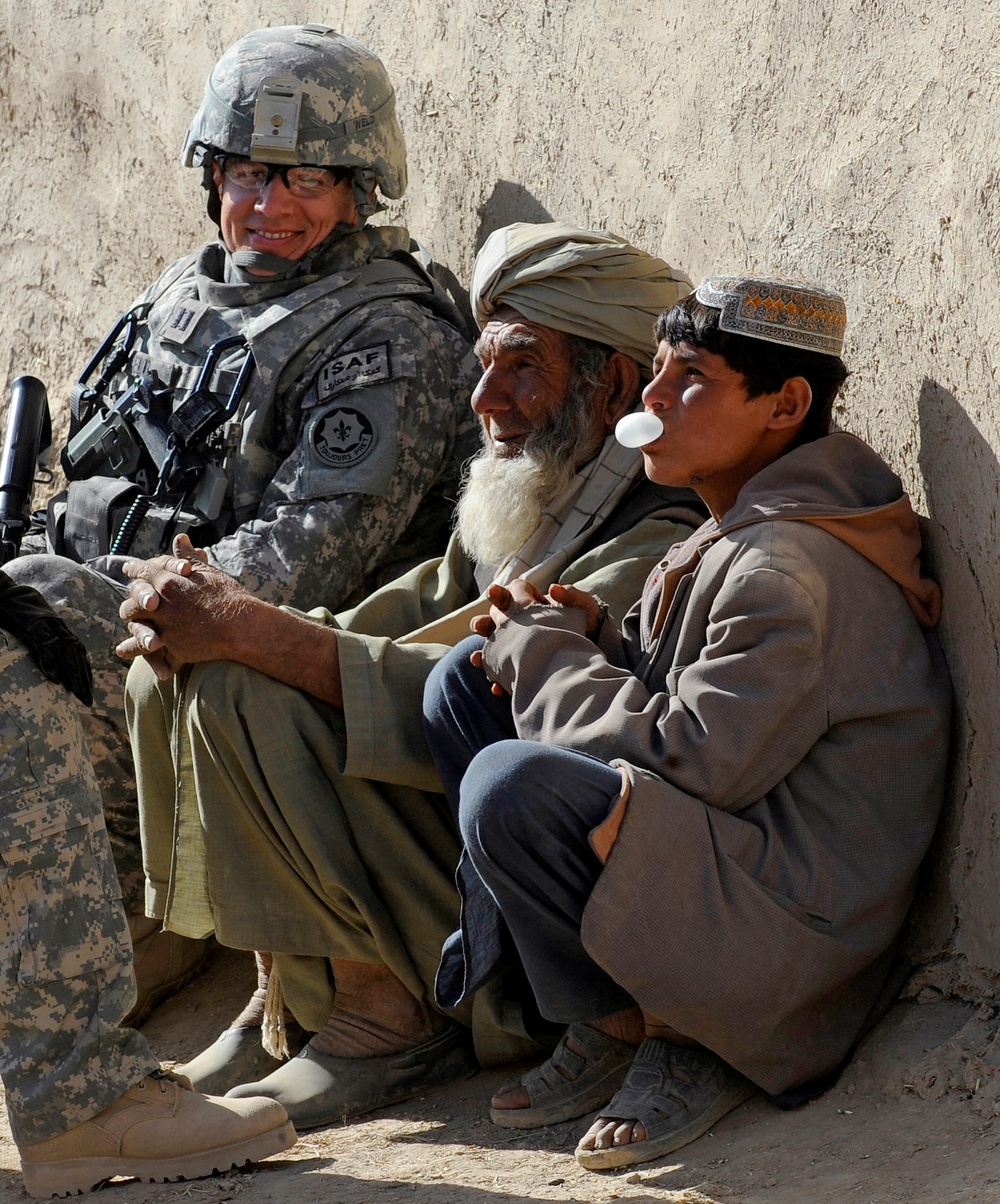 Capt. Ryan Weld talks with Afghans during a wroowali, or brotherhood, mission.