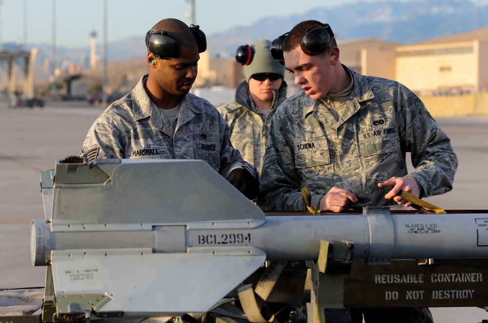 Airman 1st Class Michael Schena and Staff Sgt. Melvin Marshall prepare an AIM-9M Sidewinder missile for loading.