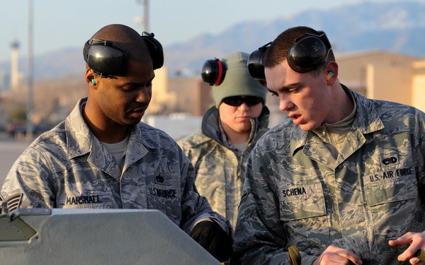 Airman 1st Class Michael Schena and Staff Sgt. Melvin Marshall prepare an AIM-9M Sidewinder missile for loading.