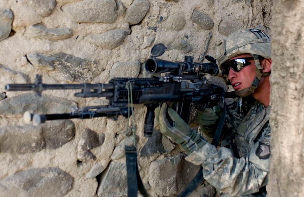 Spc. Kyle Oszczakiewicz scans for insurgents as the platoon receives small-arms fire.
