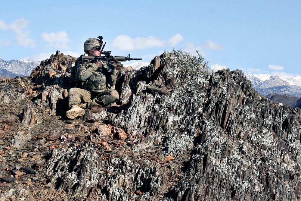 Sgt. Nick Andrews looks into the valley from a mountaintop outside the village of Nengaresh.