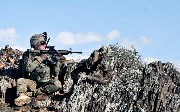 Sgt. Nick Andrews looks into the valley from a mountaintop outside the village of Nengaresh.