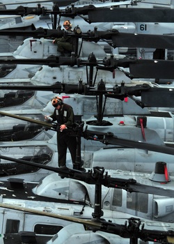 Marines conduct routine maintenance on helicopters assigned to Marine Medium Squadron 163.