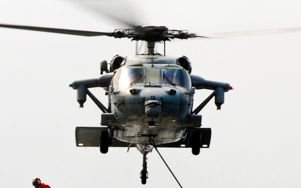 An MH-60S Seahawk helicopter transports humanitarian assistance supplies.