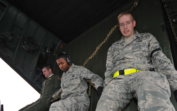 U.S. Air Force airmen load communication equipment into a C-130 Hercules aircraft.