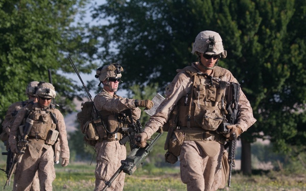 Cpl. Ben W. Gibson sweeps for explosive devices with a metal detector.