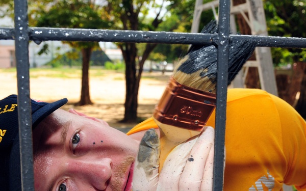 Petty Officer 2nd Class Jason Barcellos paints part of the Muang Phuket School in Chalong, Thailand.