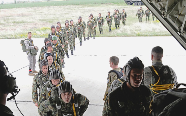Members from the 435th Security Forces Squadron usher more than 50 Bulgarian air force paratroopers into a C-130J Super Hercules aircraft.