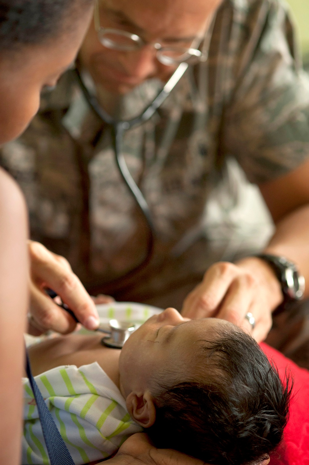 Maj. Gary Ruesch examines a young patient at the Escuela Max Seidel medical site.