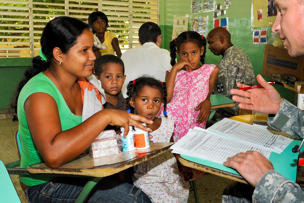 Maj. Dr. Matthew Johnson talks to a Dominican mother about medication doses.