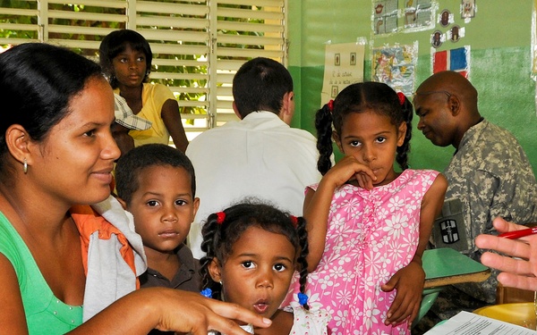 Maj. Dr. Matthew Johnson talks to a Dominican mother about medication doses.