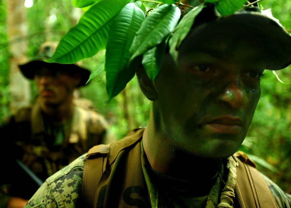 Sgt. Kairo Ortez and Petty Officer 3rd Class Marcus Green patrol the jungle in the Eram Sisik training area.