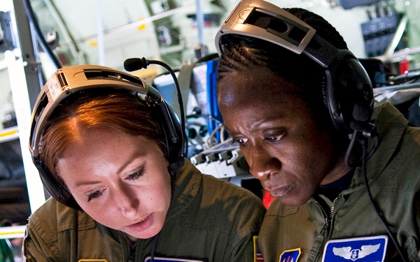 Staff Sgt. Donna Francis and Capt. Clementine Duke review Air Force Instructions aboard an C-130J Hercules.