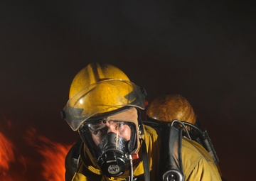 Petty Officer 1st Class Hector Floresdiaz demonstrates firefighting techniques to students.