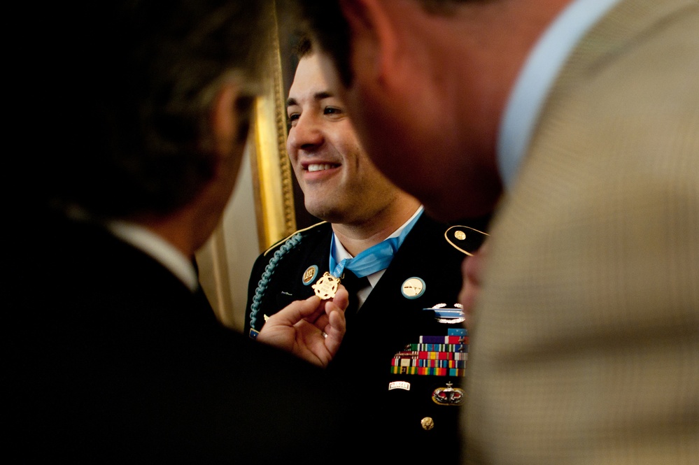 Friends of Army Sgt. 1st Class Leroy Arthur Petry inspect the Medal of Honor he received at the White House.