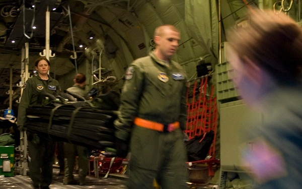 U.S. Air Force airmen unload medical equipment from an Air Force C-130J Hercules aircraft.