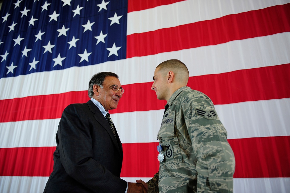 Secretary Panetta shakes hands with Senior Airman Brian Colasacco.