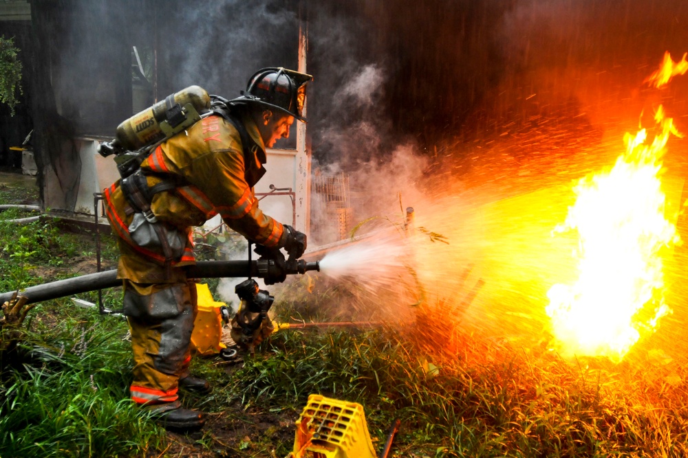 Pvt. 1st Class Lucas Ternell puts out a small debris fire in a yard.