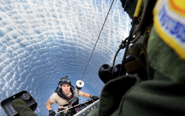 Air Force Pararescueman Staff Sgt. Jacob Schaumberg is hoisted up to an HH-60