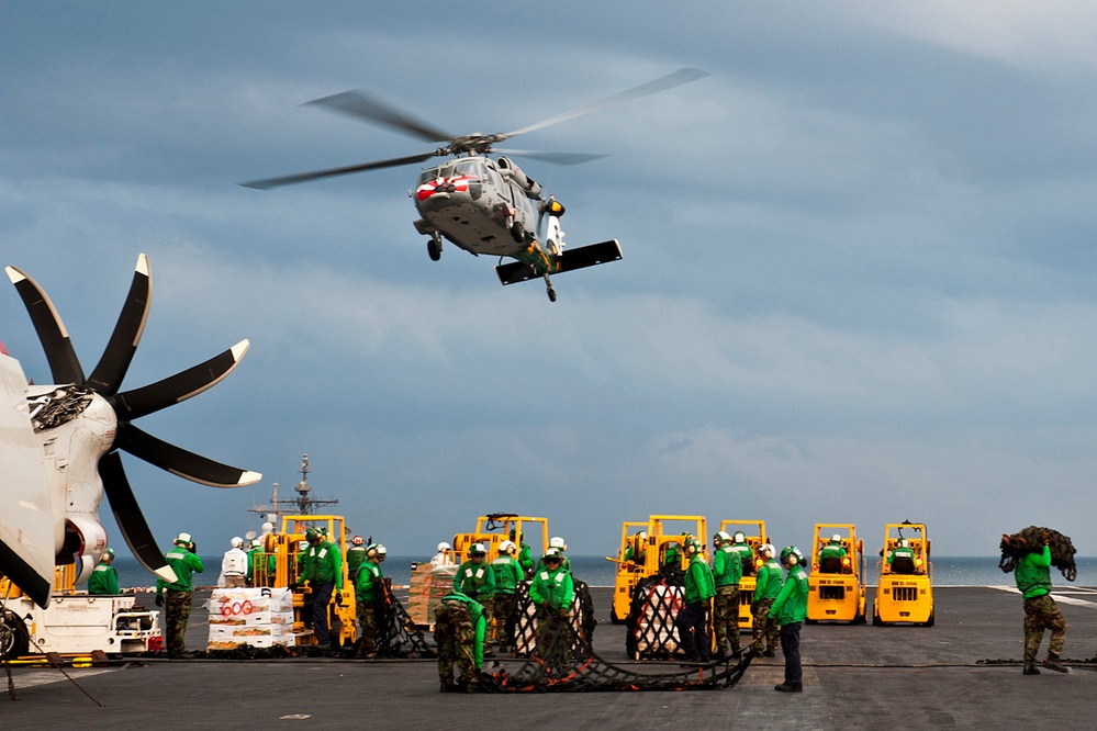 U.S. Navy sailors aboard the aircraft carrier USS John C. Stennis prepare cargo nets.
