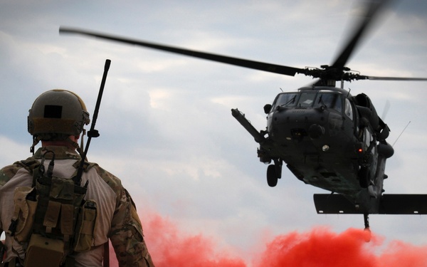 Maj. Matthew McGuinness pops a flare to signal an HH-60G Pave Hawk where to land.