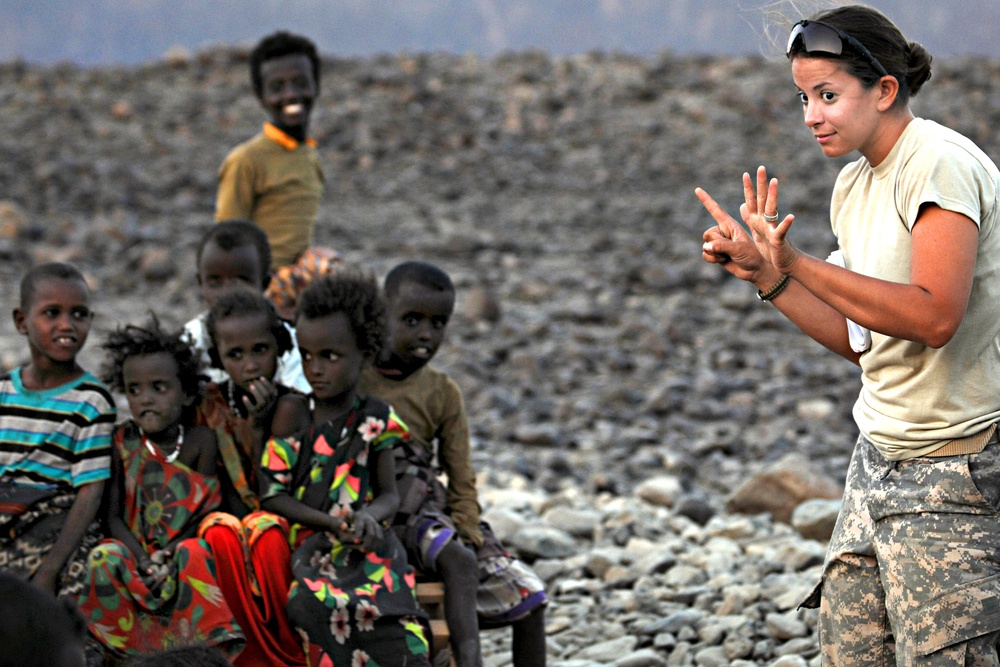 Spc. Tiffany Larriba raises six fingers while playing a game with children during the &quot;Soldier in the Classroom&quot; program/