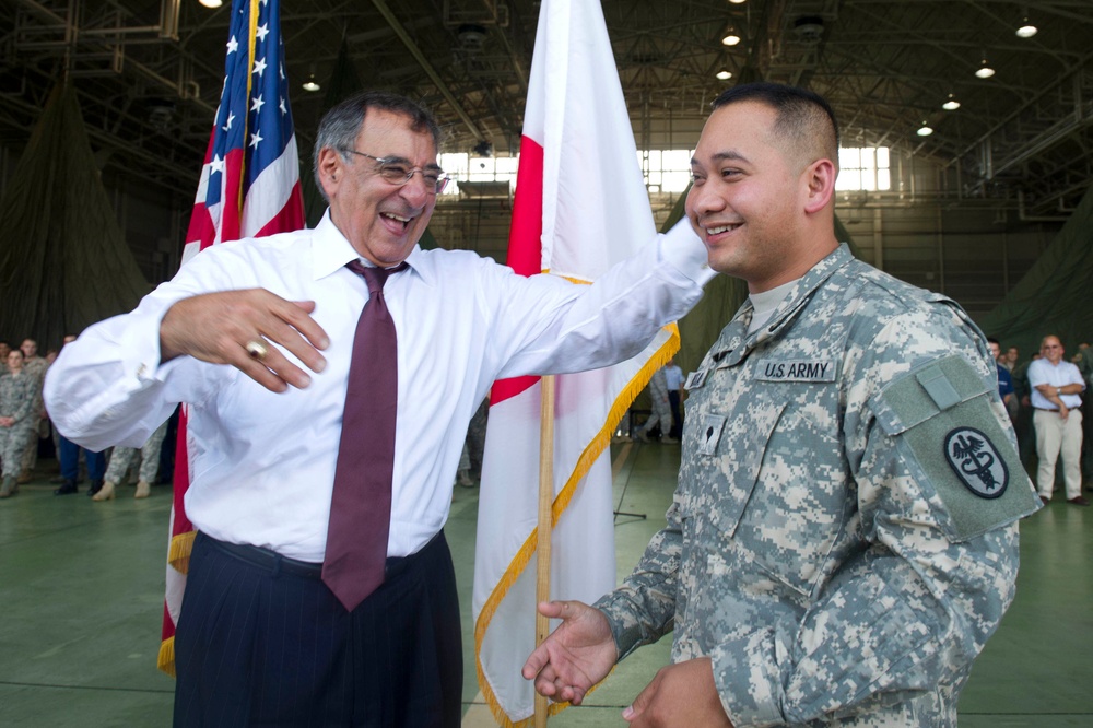 Secretary Panetta laughs with a soldier at Yokota Air Base
