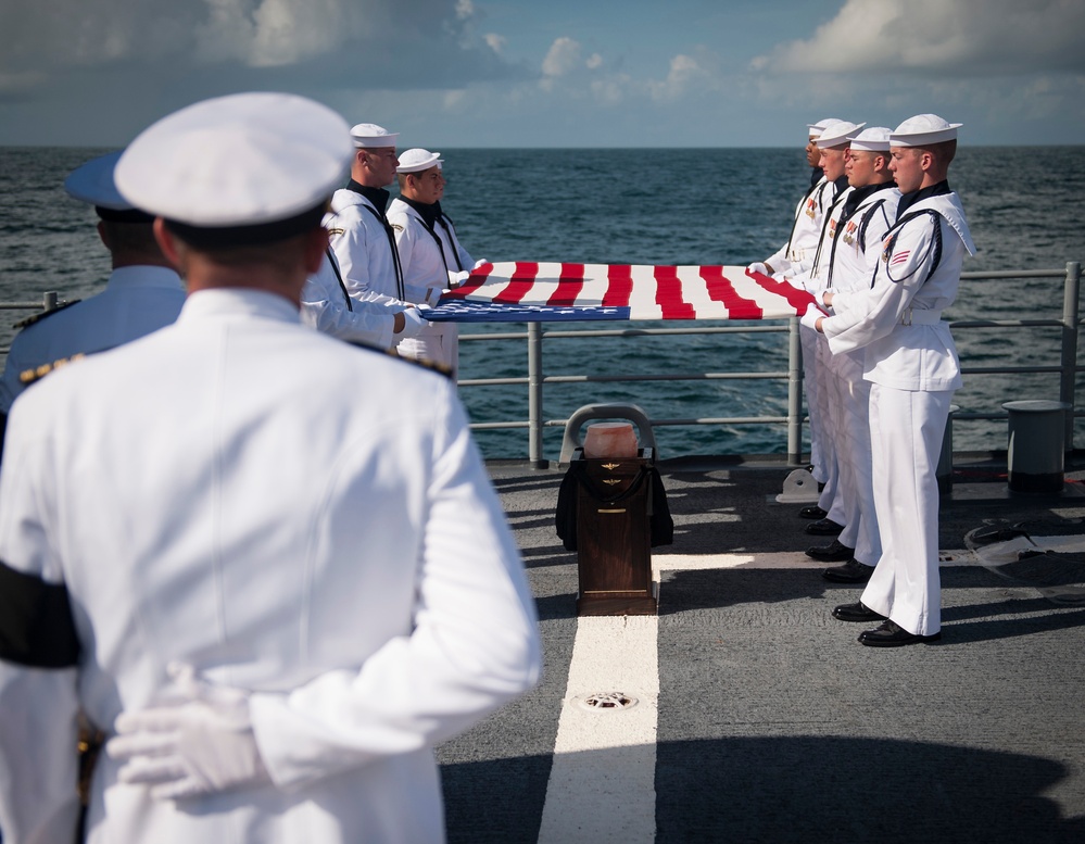 Members of the U.S. Navy Ceremonial Guard hold an American flag over the remains of Apollo 11 astronaut Neil Armstrong