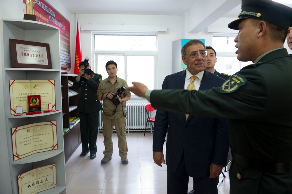 A cadet of the People's Liberation Army Armored Forces Academy shows Secretary Panetta the most difficult medals to win