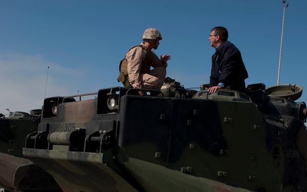 Deputy Secretary Carter speaks with  Staff Sgt. Michael Burkheart atop an amphibious assault vehicle