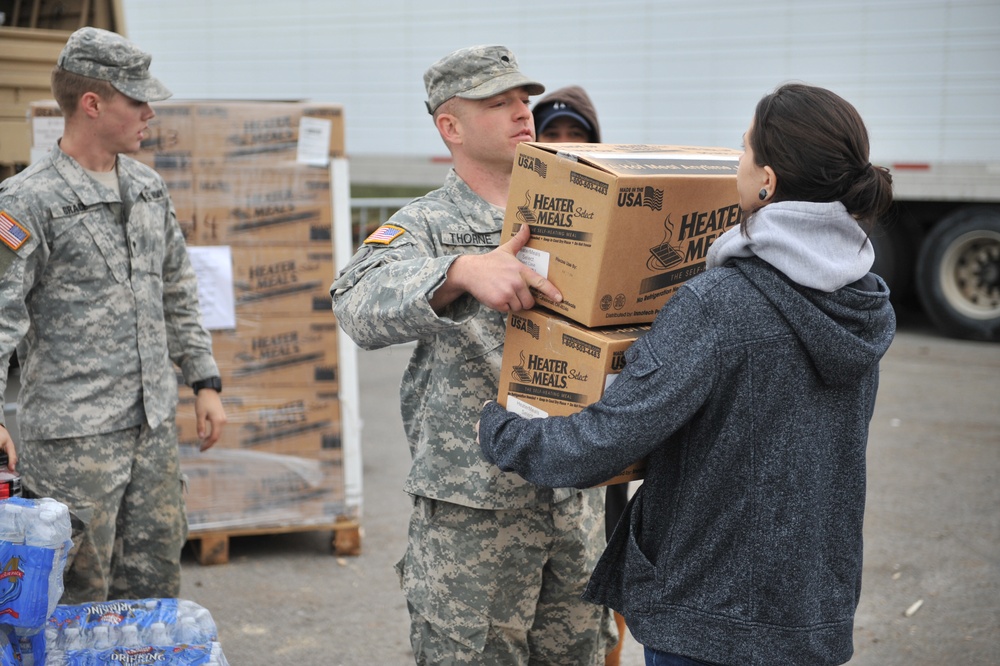 A soldier hands a box of meals to a resident in Long Beach, N.Y