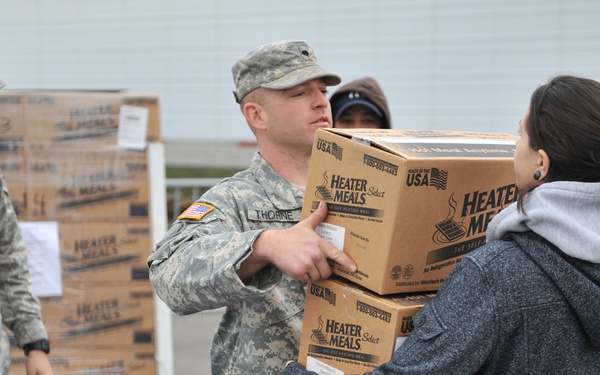 A soldier hands a box of meals to a resident in Long Beach, N.Y