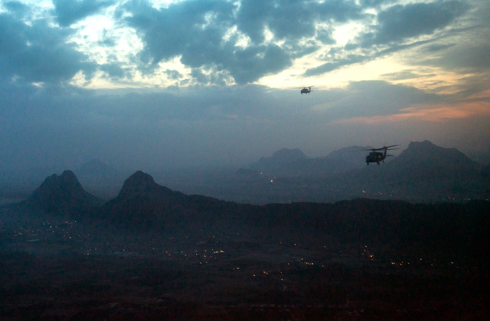 U.S. Army UH-60 Black Hawk helicopters fly over Kandahar