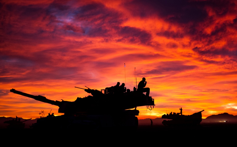 The crews of U.S. Marine Corps M1A1 Abrams tanks prepare for the start of the day’s events