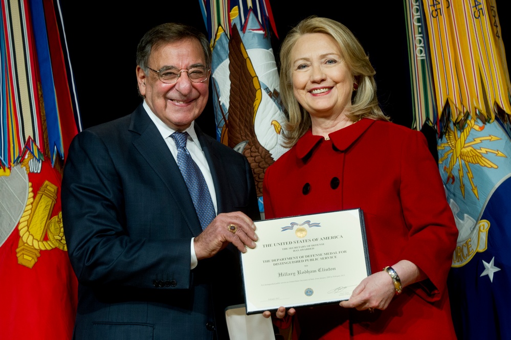 Secretary Panetta presents former Secretary Clinton with a medal