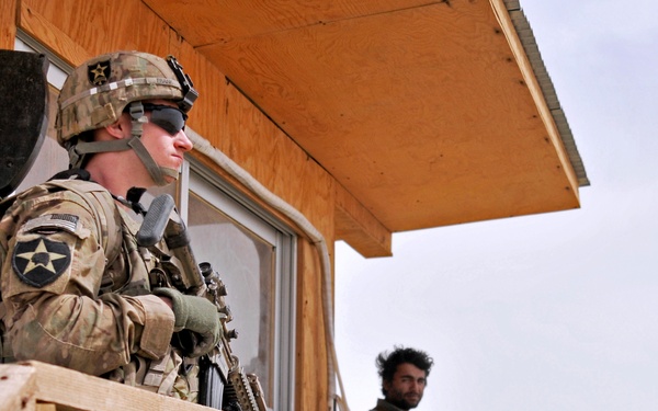 Army Pfc. Scott Frank and Afghan Uniformed Police provide security at a police checkpoint