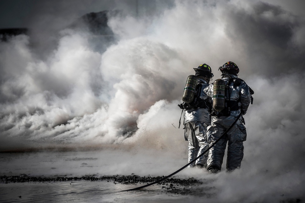 U.S. Air Force firefighters extinguish a fire during a fire training exercise