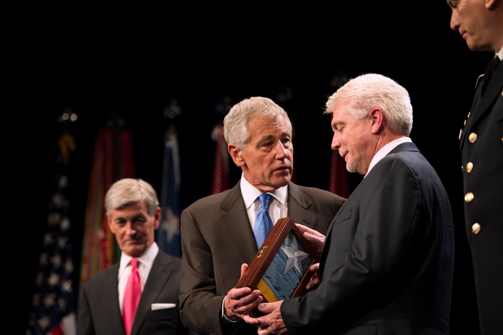 Secretary Hagel presents the Medal of Honor flag to Ray Kapaun