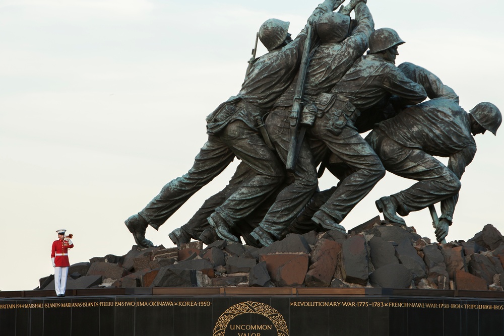 Staff Sgt. Codie Williams plays taps as she stands atop the Marine Corps War Memorial
