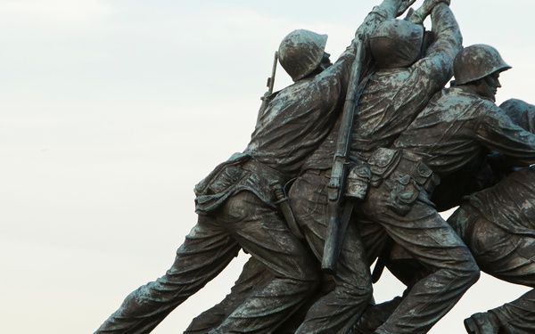 Staff Sgt. Codie Williams plays taps as she stands atop the Marine Corps War Memorial
