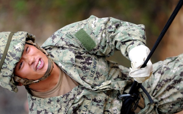 Navy Seabee Petty Officer 3rd Class Andrew Fabella rappels down a 63-foot training wall