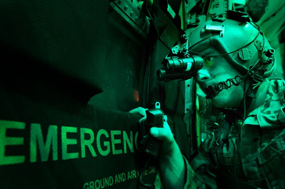 Senior Airman Larry Webster uses night vision goggles to scan for potential threats