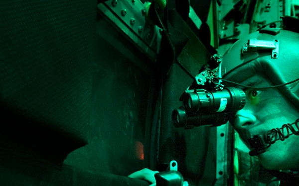 Senior Airman Larry Webster uses night vision goggles to scan for potential threats