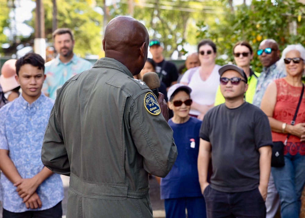 Rear Adm. Stephen Barnett, commander, Navy Region Hawaii (CNRH), speaks with community members as they wait at the Commander, U.S. Pacific Fleet (COMPACFLT) boathouse to board a boat for a guided tour.