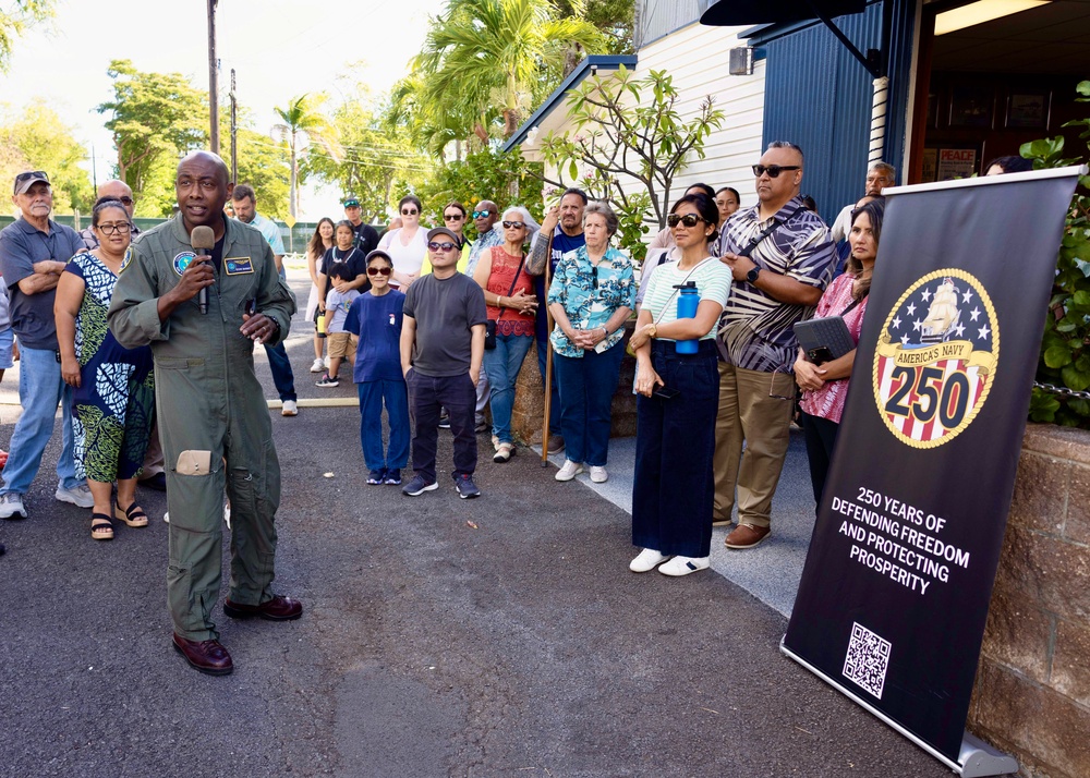 Rear Adm. Stephen Barnett, commander, Navy Region Hawaii (CNRH), speaks with community members as they wait at the Commander, U.S. Pacific Fleet (COMPACFLT) boathouse to board a boat for a guided tour.