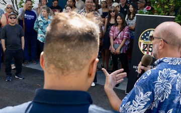 Commander, Navy Region Hawaii (CNRH) historian, James Newman, speaks with community members as they wait at the Commander, U.S. Pacific Fleet (COMPACFLT) boathouse to board a boat for a guided tour.