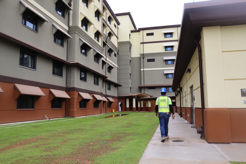 A Construction Worker Walks Alongside New Bachelor Enlisted Quarters on Camp Blaz
