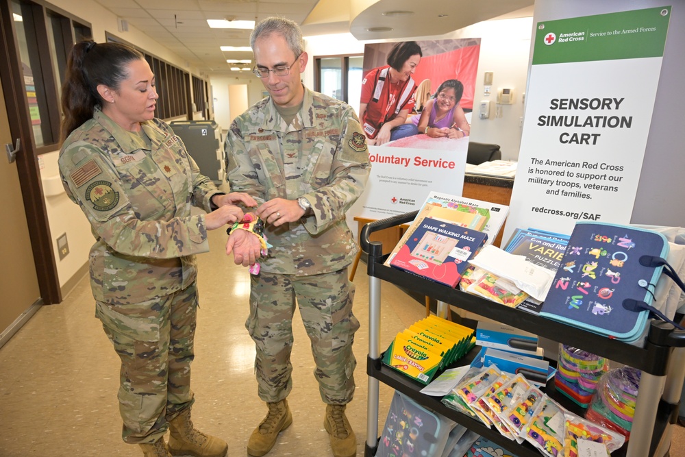 Maj. Bonnie Sgroi, 60th Inpatient Squadron clinical nurse specialist, demonstrates one of the sensory tools to Col. Patrick Parsons